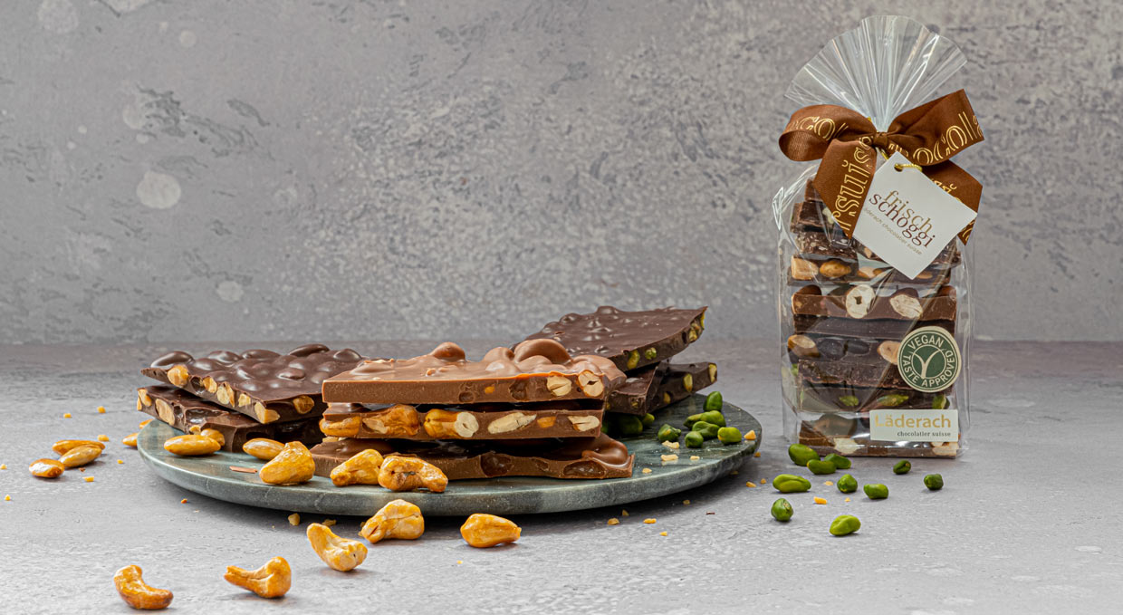 vegan-chocolate-made-from-cashews-in-milk-and-dark-chocolate-laid-out-on-a-table-with-pistachios-and-cashews.jpg